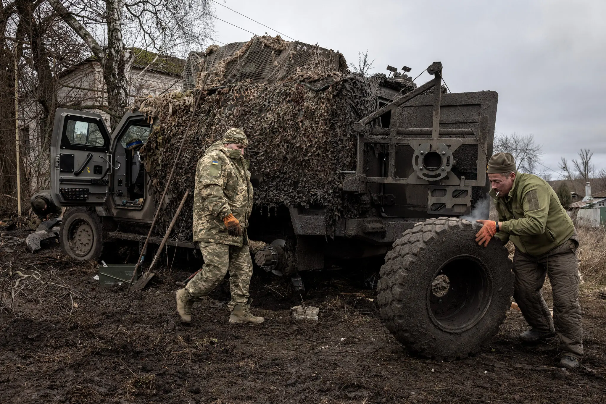 Українські військові ремонтують автомобіль біля кордону з Росією.